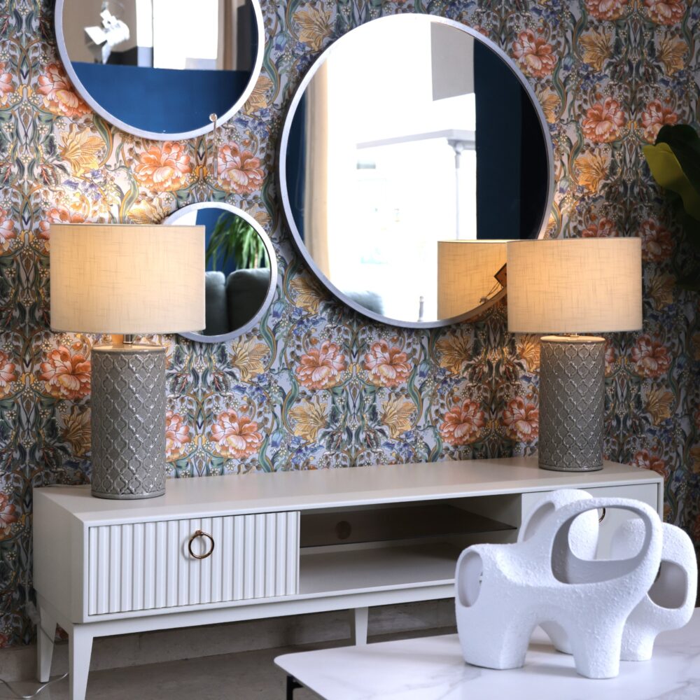 mueble tv lacado blanco con pata alta y detalles en dorado.