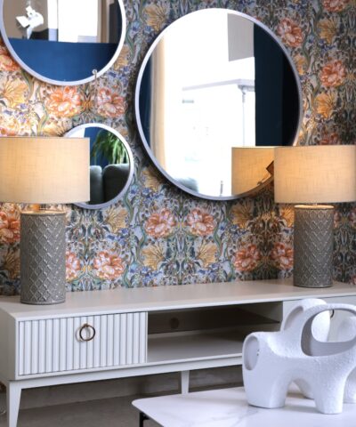 mueble tv lacado blanco con pata alta y detalles en dorado.